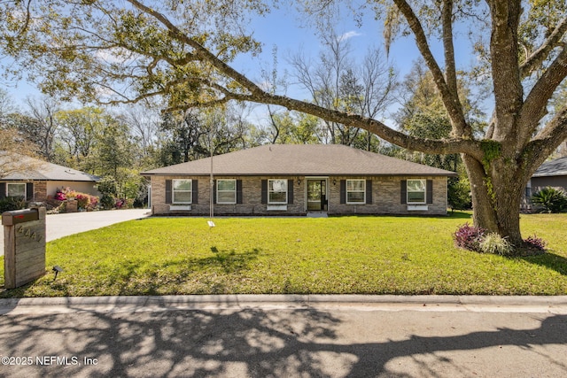 ranch-style house with brick siding, driveway, a shingled roof, and a front yard