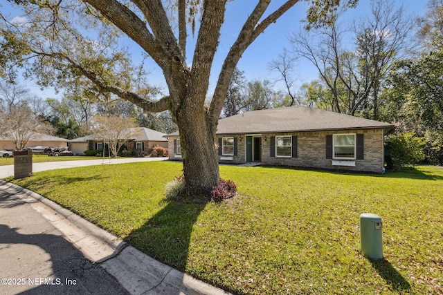 ranch-style home with concrete driveway, brick siding, and a front yard