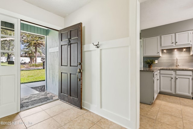 foyer featuring light tile patterned floors and a textured ceiling