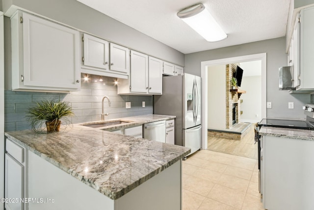 kitchen featuring a sink, light stone countertops, tasteful backsplash, and appliances with stainless steel finishes