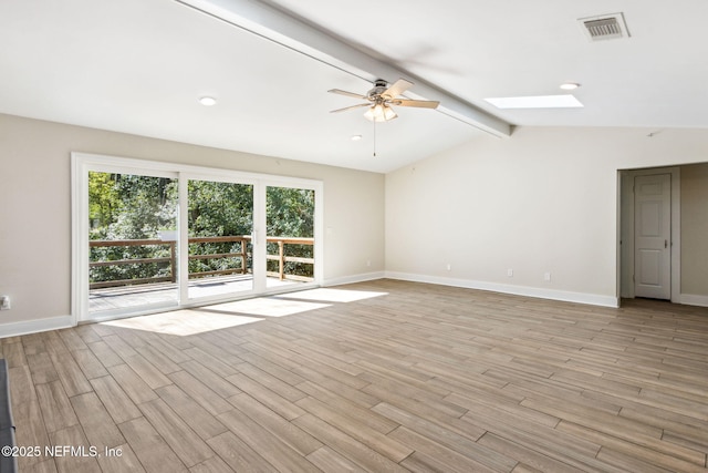 spare room featuring visible vents, lofted ceiling with skylight, light wood-style flooring, baseboards, and ceiling fan