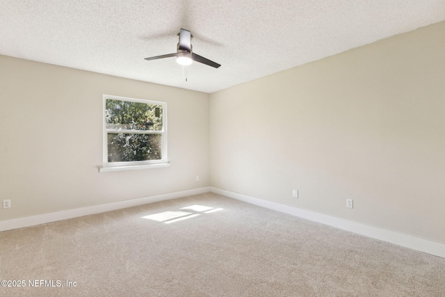 carpeted empty room featuring baseboards, a textured ceiling, and ceiling fan