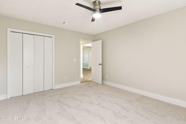 unfurnished bedroom with a closet, baseboards, a ceiling fan, and carpet flooring