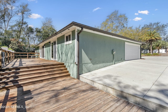 view of property exterior featuring a wooden deck and a detached garage