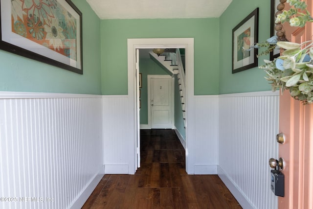 346 N Cherry St, Starke, FL 32091 - hallway with dark wood-style flooring, stairs, and wainscoting