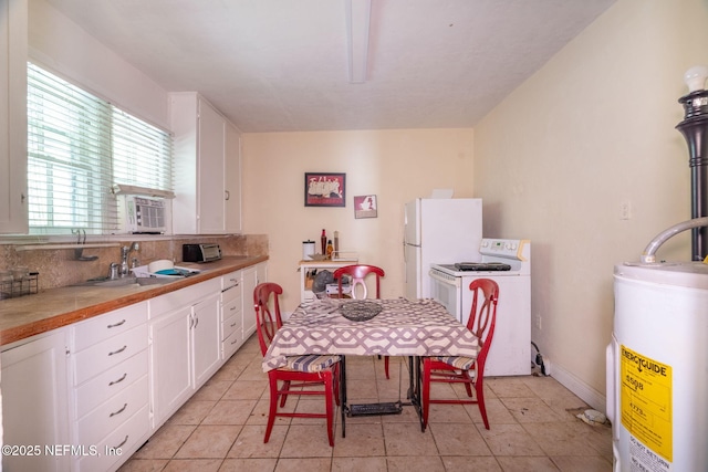 346 N Cherry St, Starke, FL 32091 - kitchen featuring white appliances, tasteful backsplash, water heater, white cabinetry, and a sink