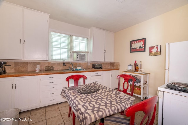 346 N Cherry St, Starke, FL 32091 - kitchen with decorative backsplash, white cabinets, a sink, and white appliances
