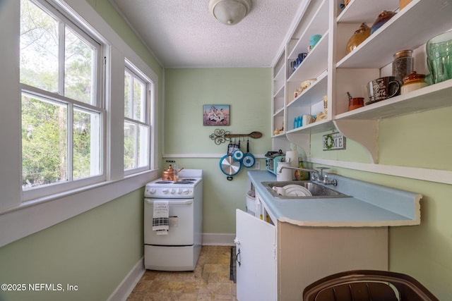 346 N Cherry St, Starke, FL 32091 - kitchen featuring a textured ceiling, light countertops, baseboards, a sink, and white range with electric stovetop