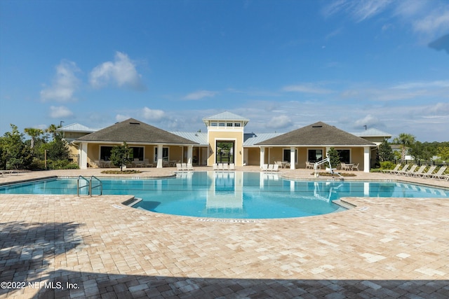 community pool with a patio and fence