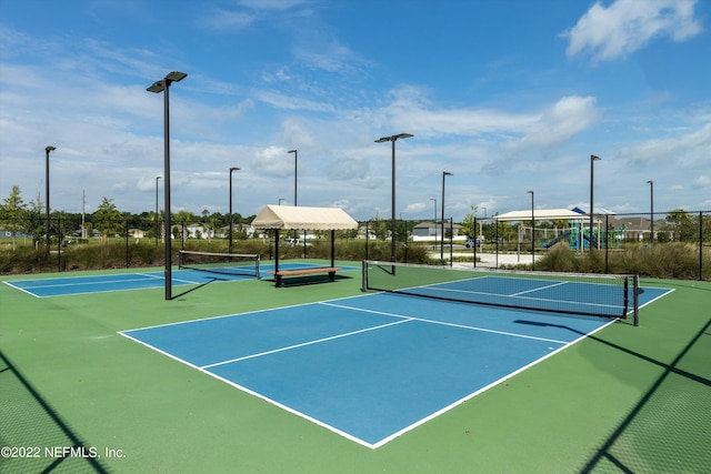 view of sport court with community basketball court, fence, and playground community