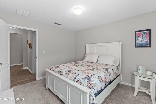 bedroom with visible vents, baseboards, and light colored carpet