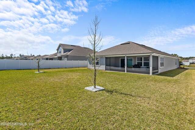 back of house featuring a sunroom, a lawn, and fence