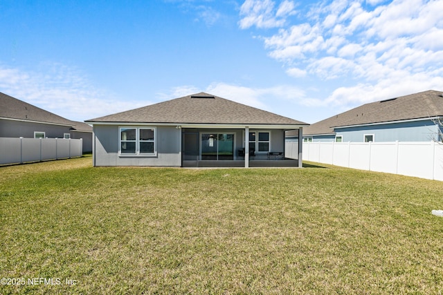 rear view of property featuring a lawn, a fenced backyard, a sunroom, and stucco siding