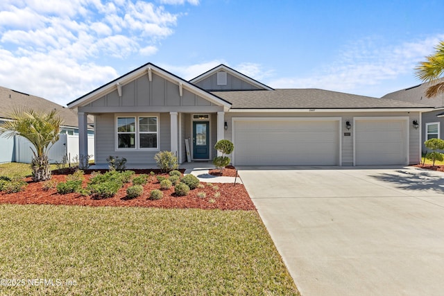 view of front of home with board and batten siding, a front lawn, fence, concrete driveway, and a garage