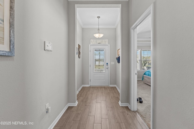 entryway featuring crown molding, baseboards, and light wood-type flooring