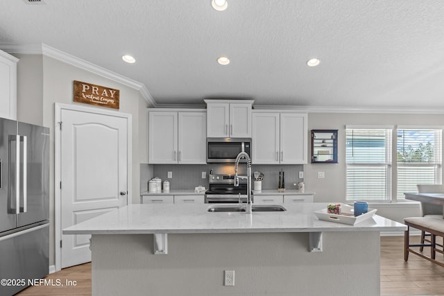 kitchen with a kitchen bar, backsplash, appliances with stainless steel finishes, and light wood-style flooring