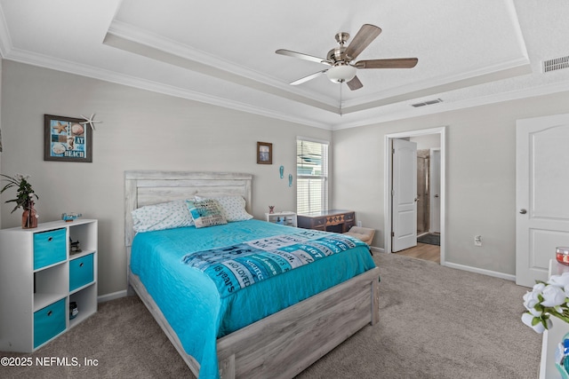 bedroom with visible vents, baseboards, a tray ceiling, carpet floors, and ornamental molding