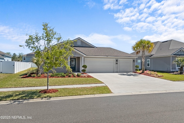 view of front of home with a front yard, concrete driveway, fence, and a garage