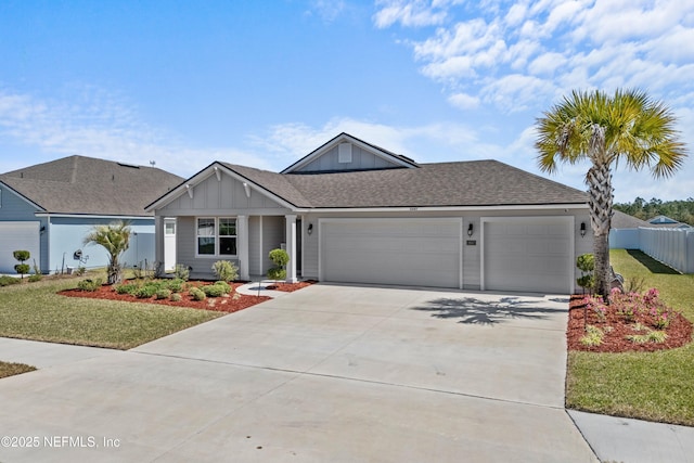 view of front facade with a front yard, fence, driveway, a shingled roof, and a garage