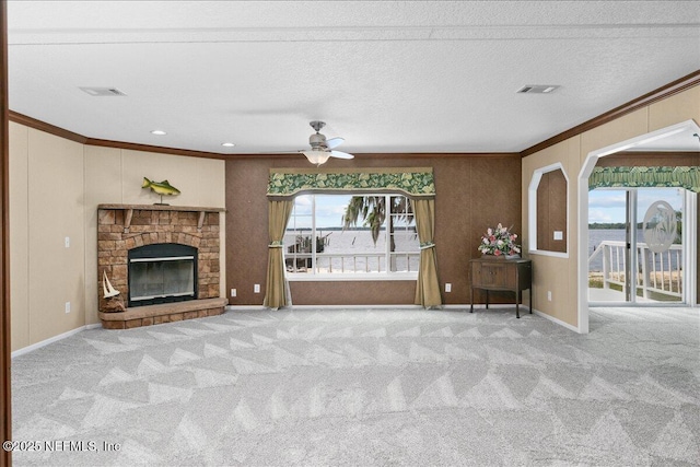 unfurnished living room with ceiling fan, carpet, visible vents, and ornamental molding