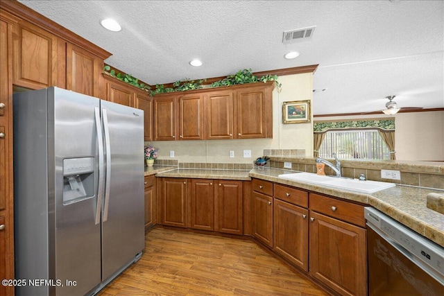 kitchen with a sink, visible vents, brown cabinets, and appliances with stainless steel finishes