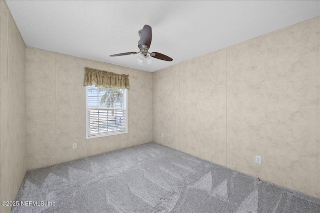 carpeted empty room featuring a ceiling fan and a textured ceiling