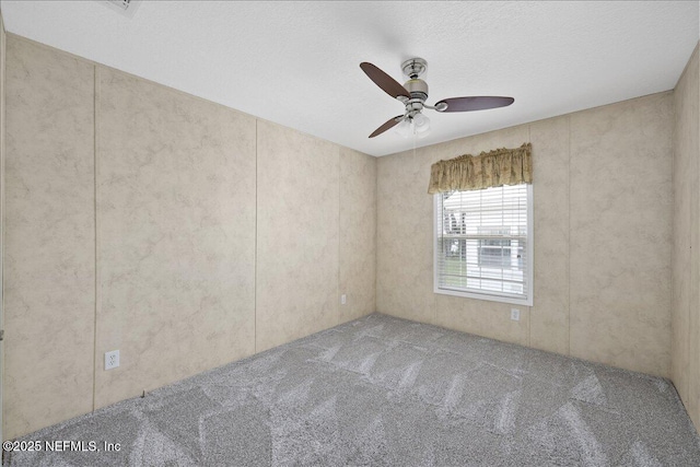 carpeted spare room with a textured ceiling and a ceiling fan