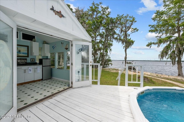 exterior space with an outdoor pool, a yard, and a water view