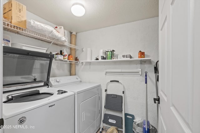 washroom with a textured wall, a textured ceiling, laundry area, and washer and clothes dryer