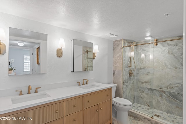 bathroom featuring a marble finish shower, double vanity, and a sink