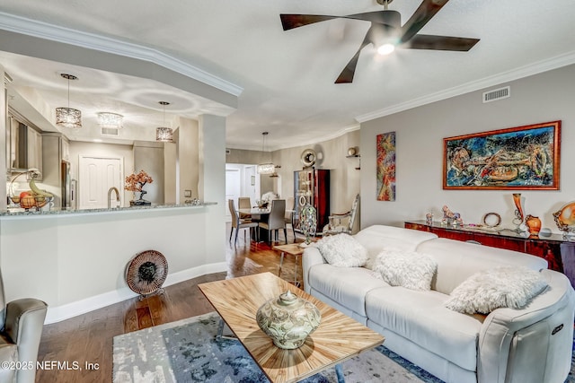 living room with visible vents, crown molding, baseboards, ceiling fan, and wood finished floors