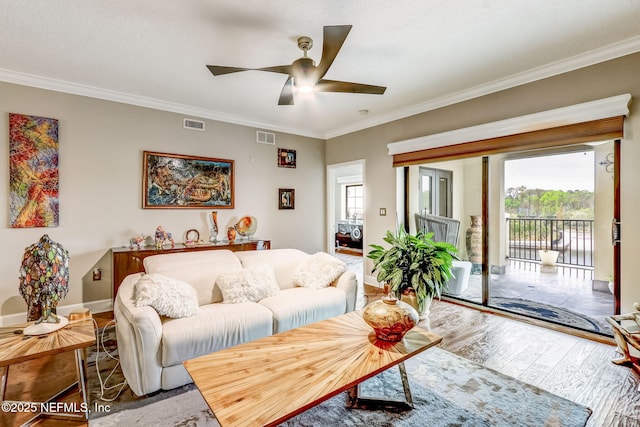 living room with visible vents, wood finished floors, ceiling fan, and crown molding