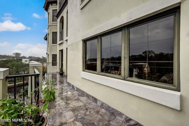 view of property exterior with stucco siding and a balcony