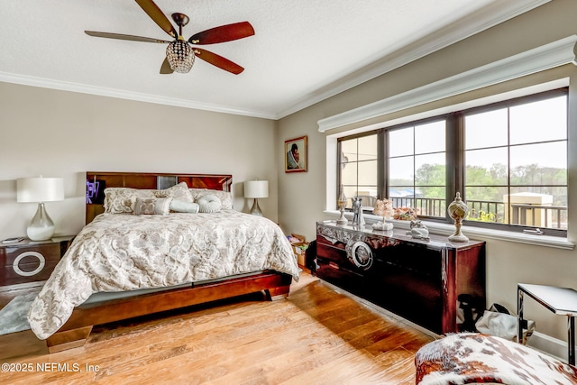 bedroom featuring ceiling fan, wood finished floors, and ornamental molding