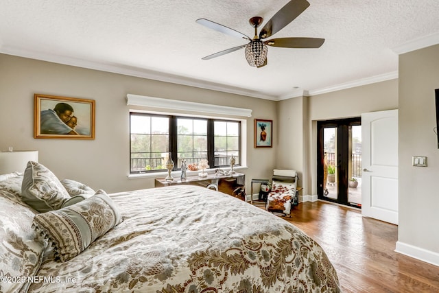 bedroom with ceiling fan, baseboards, ornamental molding, wood finished floors, and a textured ceiling