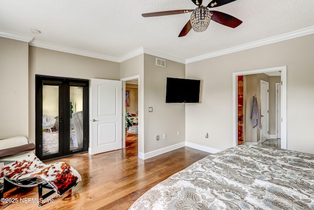 bedroom featuring access to exterior, visible vents, baseboards, french doors, and wood finished floors