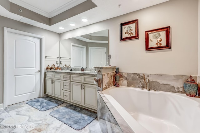 bathroom featuring a garden tub, recessed lighting, crown molding, double vanity, and a raised ceiling