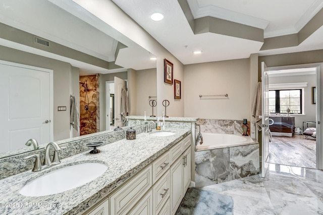 bathroom with crown molding, a garden tub, marble finish floor, and a sink