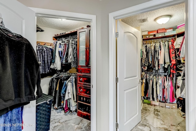 walk in closet featuring visible vents and marble finish floor