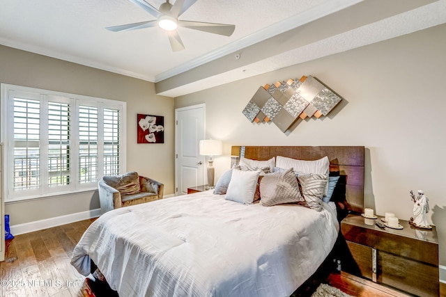 bedroom featuring crown molding, wood finished floors, baseboards, and ceiling fan