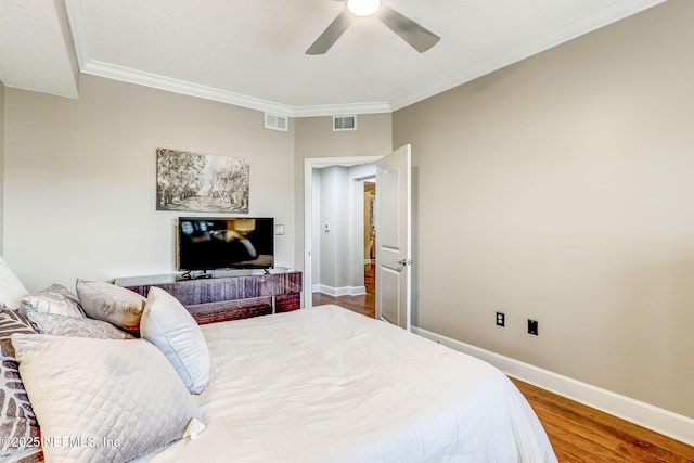 bedroom featuring visible vents, wood finished floors, baseboards, and ornamental molding