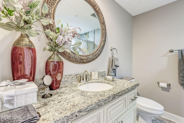 bathroom with visible vents, baseboards, toilet, and vanity