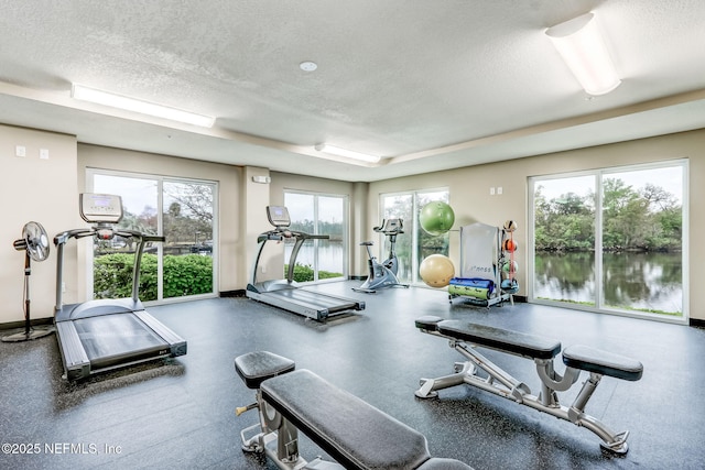 workout area featuring baseboards and a textured ceiling