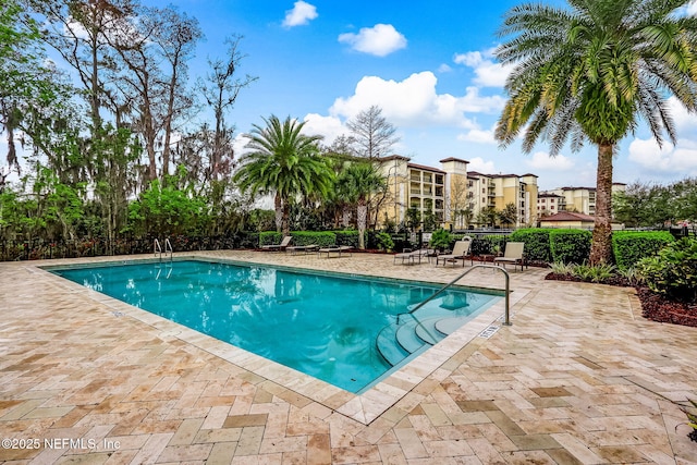 community pool featuring a patio and fence