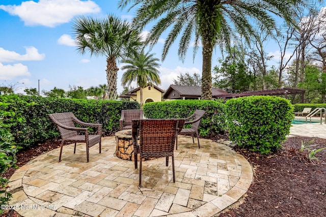 view of patio with a fenced in pool, a fire pit, and a pergola