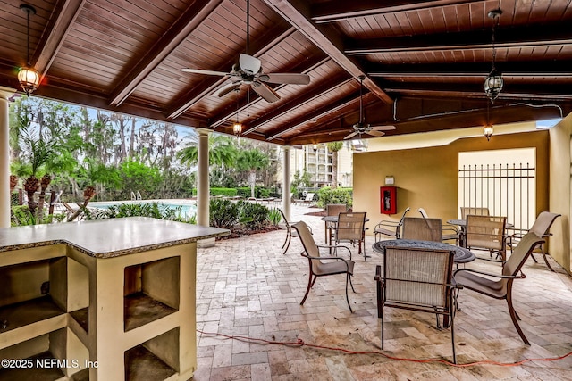 view of patio / terrace featuring a pool, outdoor dining space, and ceiling fan