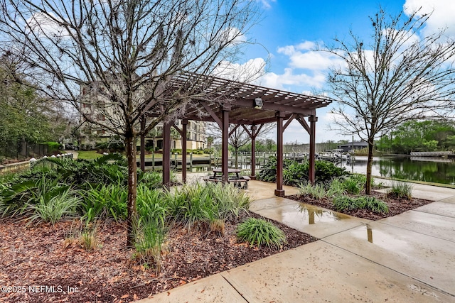 surrounding community featuring a pergola and a water view