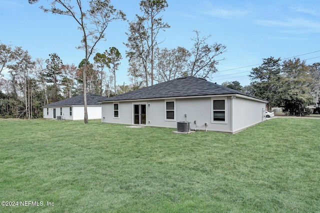 rear view of house with a lawn and central AC