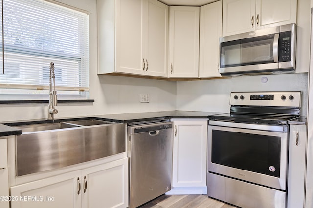 395 Arora Blvd, Orange Park, FL 32073 - kitchen with dark countertops, white cabinets, appliances with stainless steel finishes, and a sink