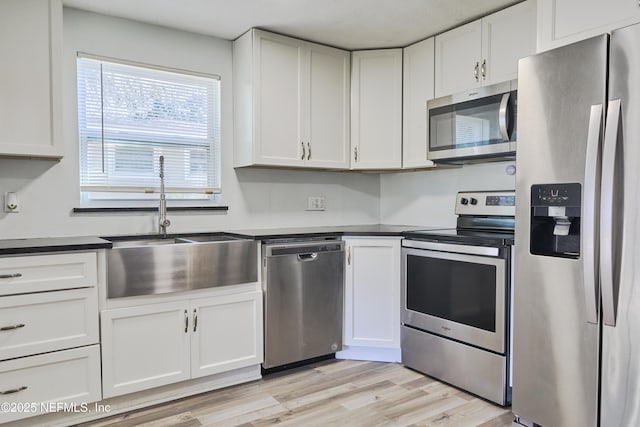 395 Arora Blvd, Orange Park, FL 32073 - kitchen featuring a sink, dark countertops, white cabinetry, appliances with stainless steel finishes, and light wood finished floors